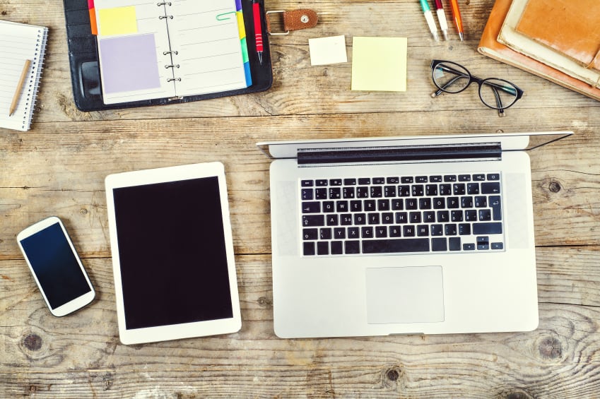 Desk with desktop computer, tablet and smart phone