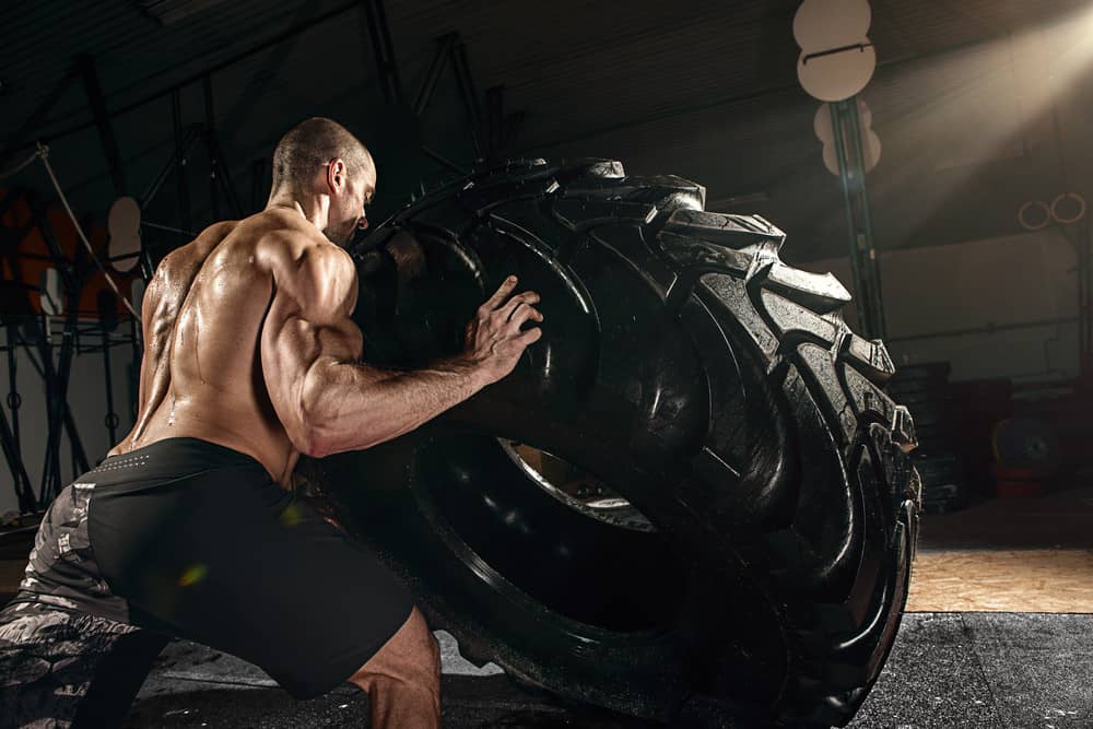 Muscular man flipping tire