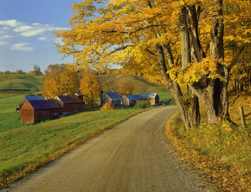 Vermont road by farm in Autumn with colorful leaves