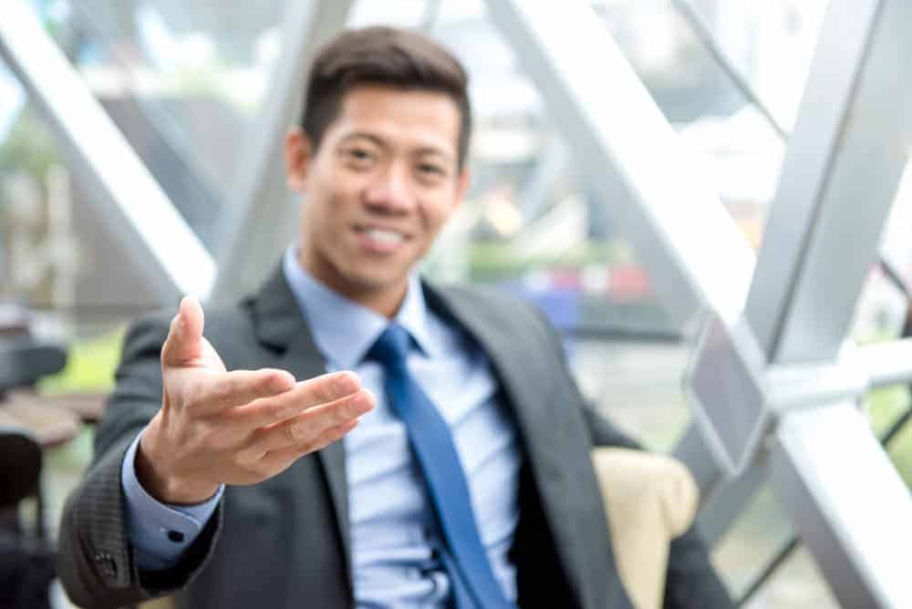 A man in suit gesticulating something.