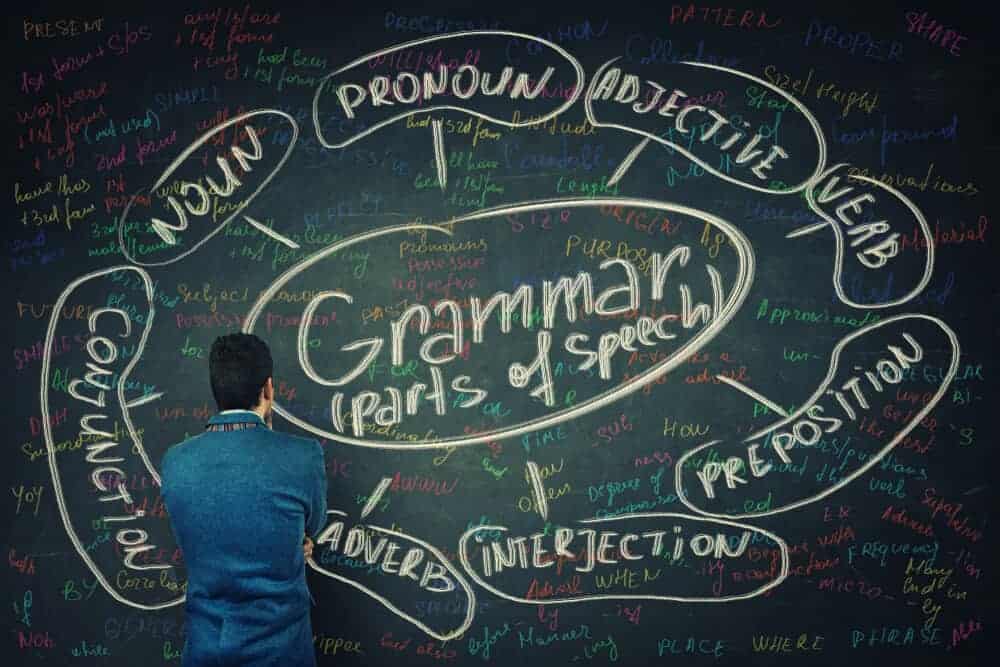 A man analyzing the parts of speech written on the blackboard.