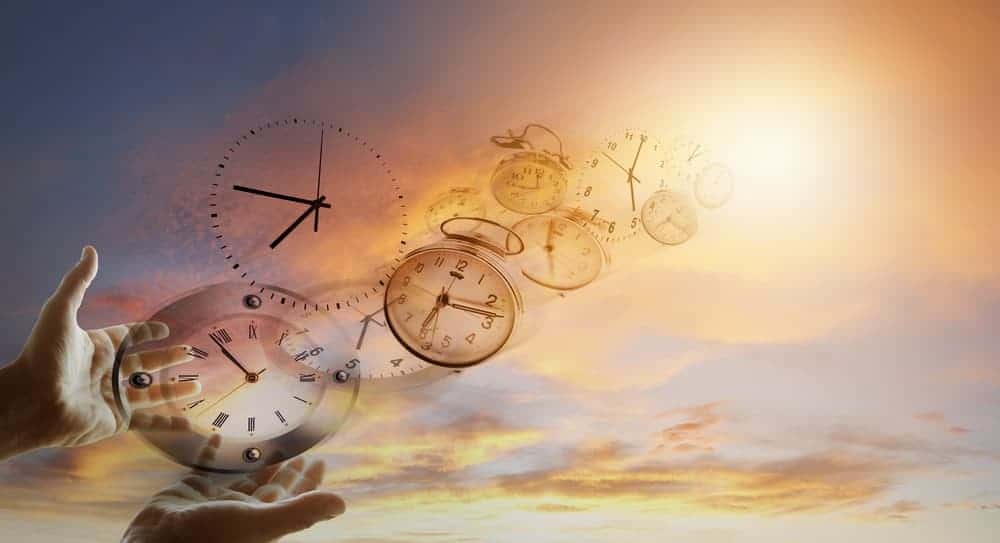 Time flies by represented by hands holding clocks that are flying towards the sky.