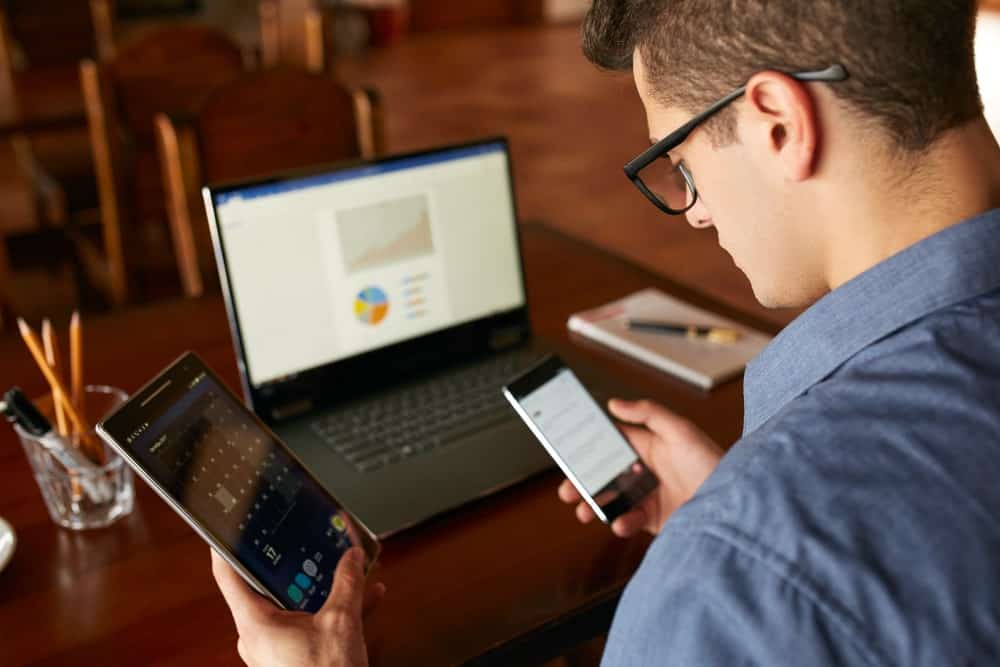 Businessman working on multiple gadgets at the same time.